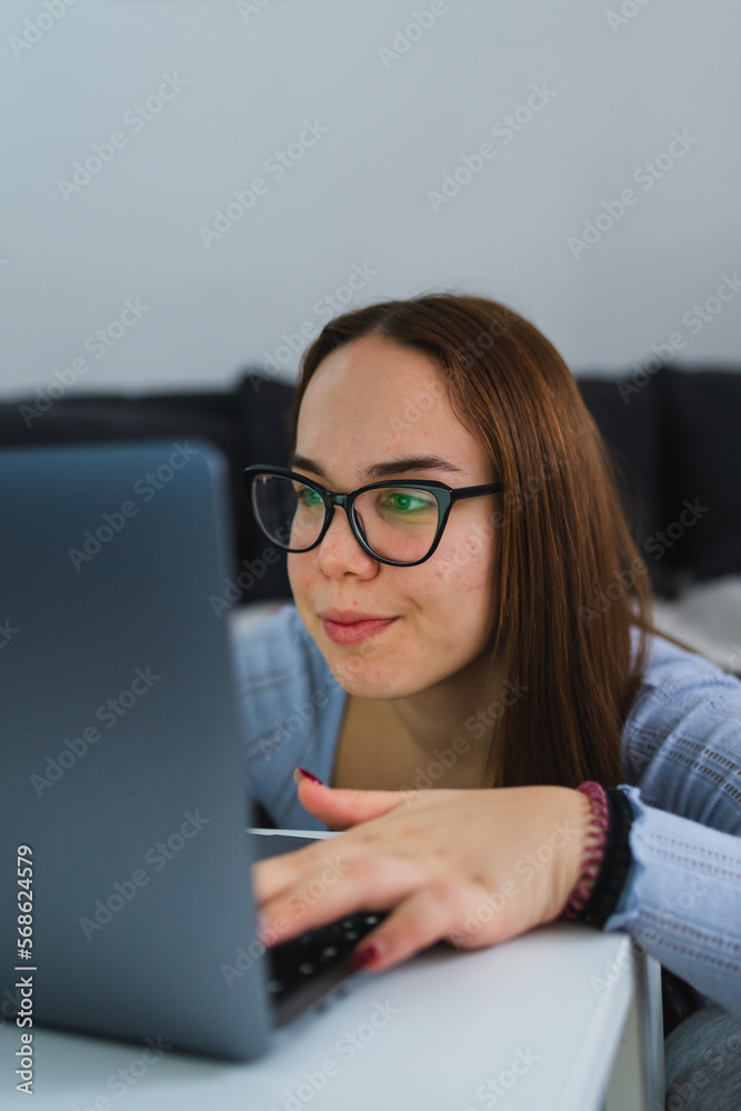 A young girl is studying or doing business from home on her laptop A young girl is studying or doing business from home on her laptop