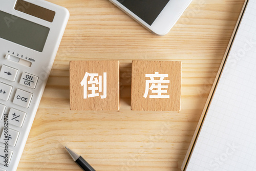 Obraz na plátně 倒産と書かれたブロックが置かれたデスク