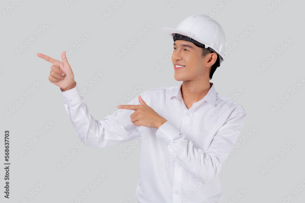 Portrait young asian man is engineer wearing helmet standing and smiling with confident isolated white background, male is architect or contractor presenting or showing something, industrial concept. Portrait young asian man is engineer wearing helmet standing and smiling with confident isolated white background, male is architect or contractor presenting or showing something, industrial concept.