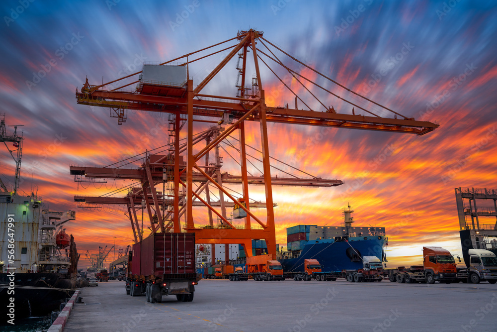 Crane loading cargo container freight container ship in the international terminal logistics sea port concept freight shipping by ship, Truck running in port under the Big Crane transport. Crane loading cargo container freight container ship in the international terminal logistics sea port concept freight shipping by ship, Truck running in port under the Big Crane transport.