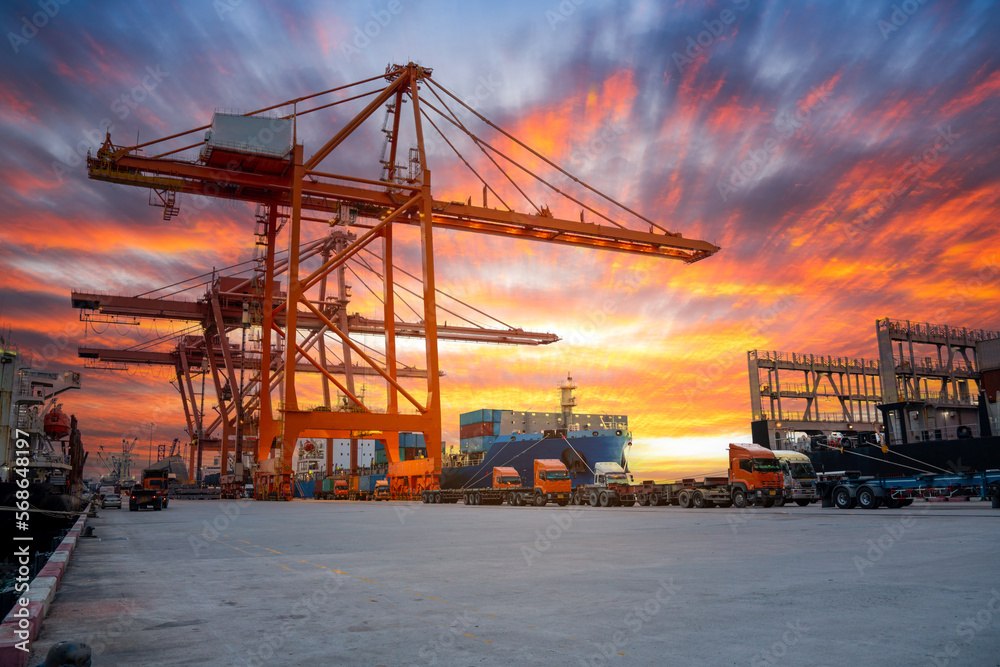 Crane loading cargo container freight container ship in the international terminal logistics sea port concept freight shipping by ship, Truck running in port under the Big Crane transport. Crane loading cargo container freight container ship in the international terminal logistics sea port concept freight shipping by ship, Truck running in port under the Big Crane transport.