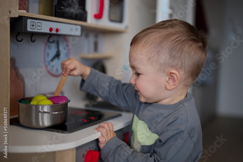 Slika na platnu Cute little toddler playing with toy kitchen set