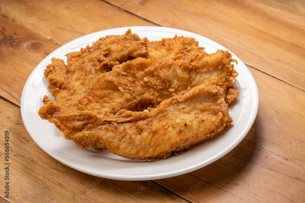 Fried chicken on white plate on wooden background. Fried chicken on white plate on wooden background.