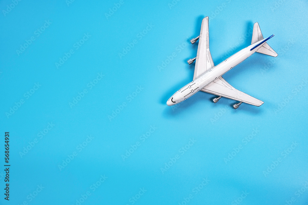 Flat lay of mini model airplane on soft blue color background with copy space , minimal style