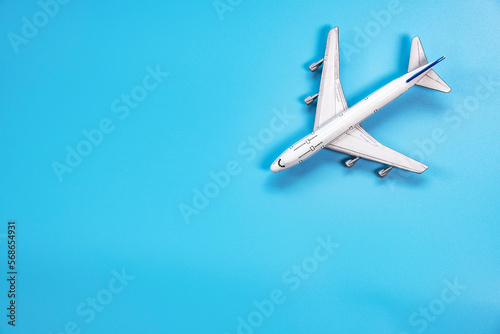 Flat lay of mini model airplane on soft blue color background with copy space , minimal style
