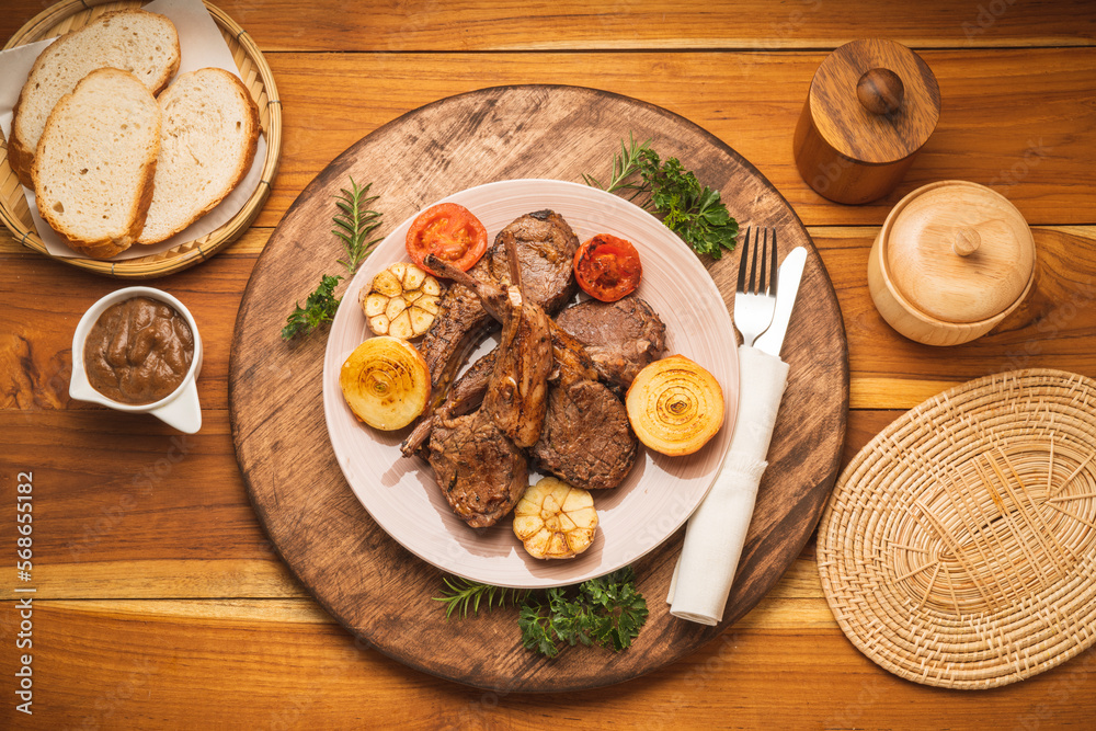 Lamp Rack Steak or Lamb chops Steak with rosemary, onion and tomato on wooden background.
