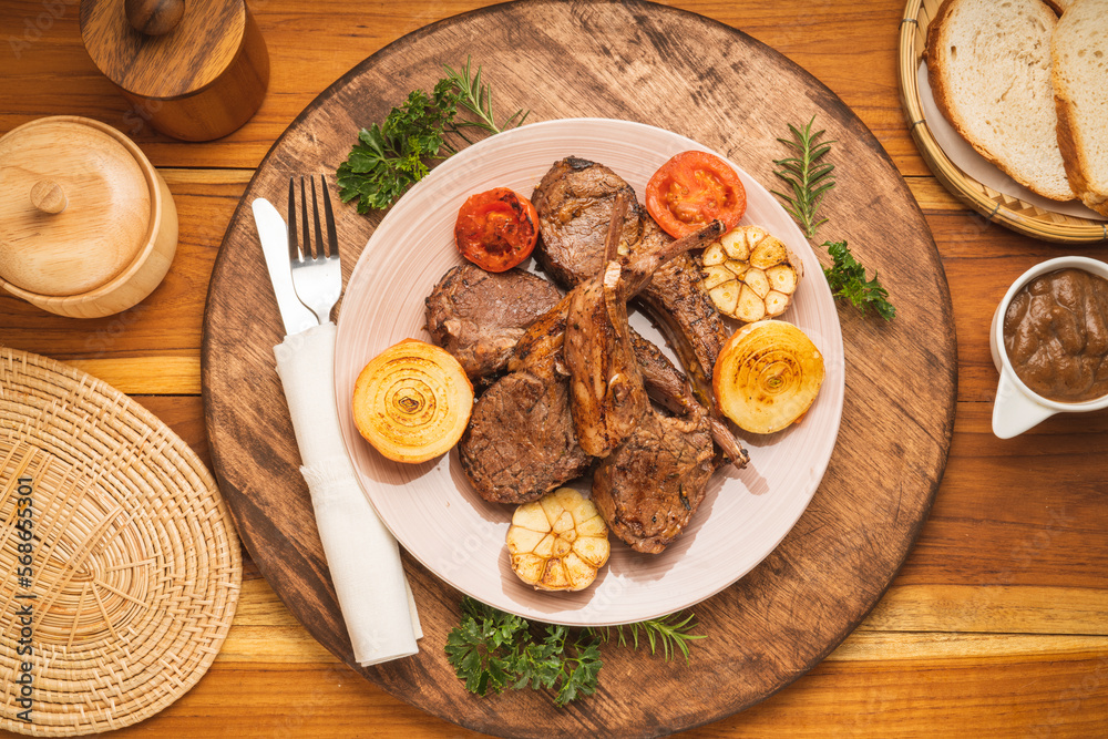 Lamp Rack Steak or Lamb chops Steak with rosemary, onion and tomato on wooden background. Lamp Rack Steak or Lamb chops Steak with rosemary, onion and tomato on wooden background.