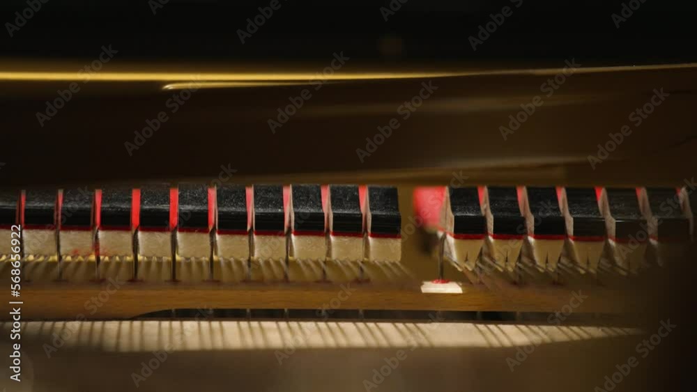Extreme closeup of an inside of a piano hammers hitting strings with shallow focus in 4k Extreme closeup of an inside of a piano hammers hitting strings with shallow focus in 4k