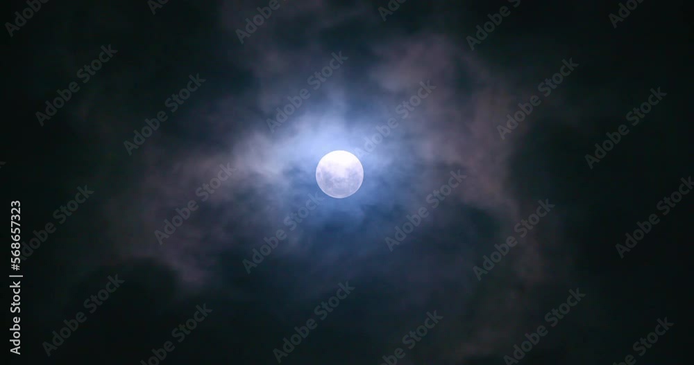 Full moon at night with clouds passing by.