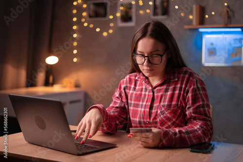 Young woman using laptop and credit card for shopping and paying online, bank client customer using credit card for online payment shopping transactions cashback loan on laptop