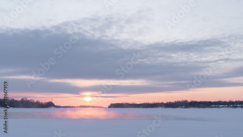 Fototapeta Naklejka Na Ścianę i Meble -  Winter sunset on the big river, hummocks in the rays of the sun.
