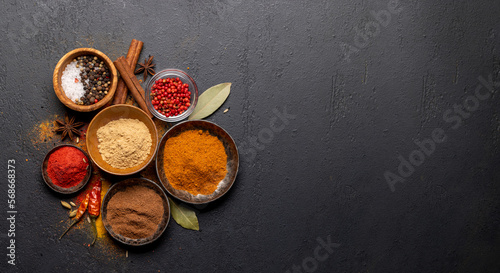 Various spices in bowls on stone table