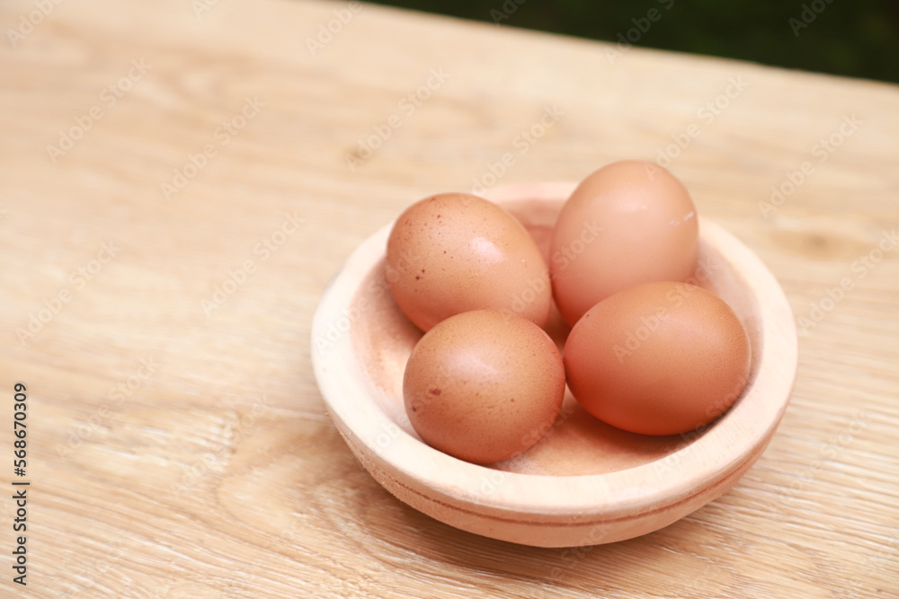 a few chicken eggs are placed in a wooden bowl a few chicken eggs are placed in a wooden bowl