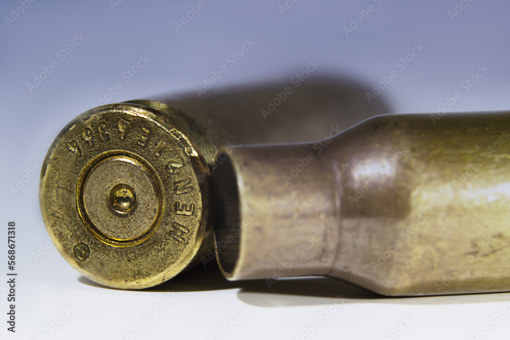 two machine gun cartridge cases on color gradient background close up two machine gun cartridge cases on color gradient background close up