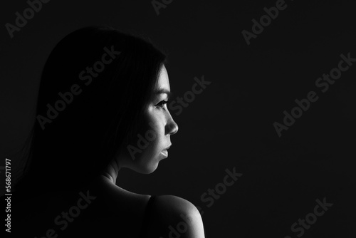Black and white fashion art studio portrait beautiful elegant woman on a black background. Loose hair. Elegant style, conceptual creative photo of a girl