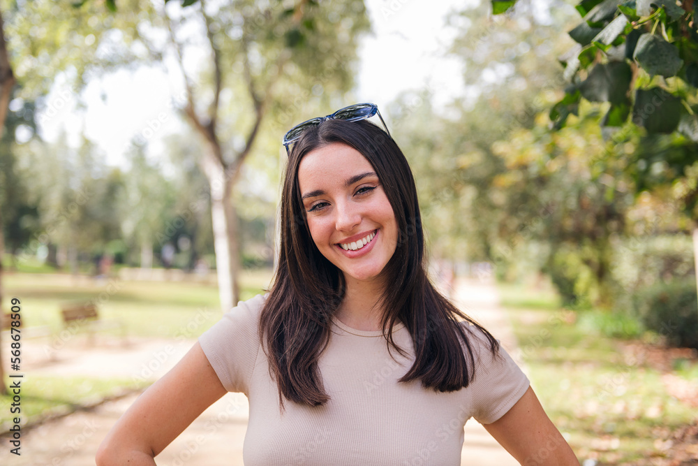 young caucasian woman looking at camera smiling with sunglasses on her head, concept of youth and beauty young caucasian woman looking at camera smiling with sunglasses on her head, concept of youth and beauty