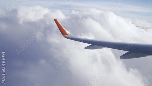 Flying in a plane through the fluffy, snow-white clouds. Spectacular view from the window of an airplane. Aircraft flies into a cluster of beautiful clouds. Ultra HD stock footage