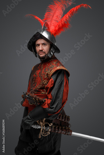 Shot of isolated on gray background conquistador with plumed helmet and epee. photo