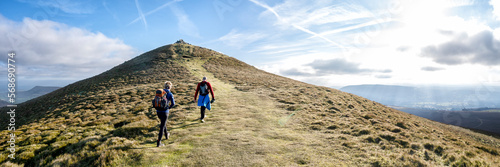 Friends hiking on mountain at sunny day