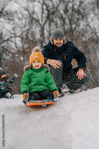 Boy sledding on snowy hill