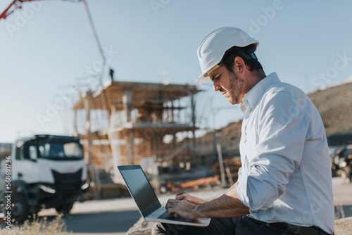 Architect using laptop at construction site