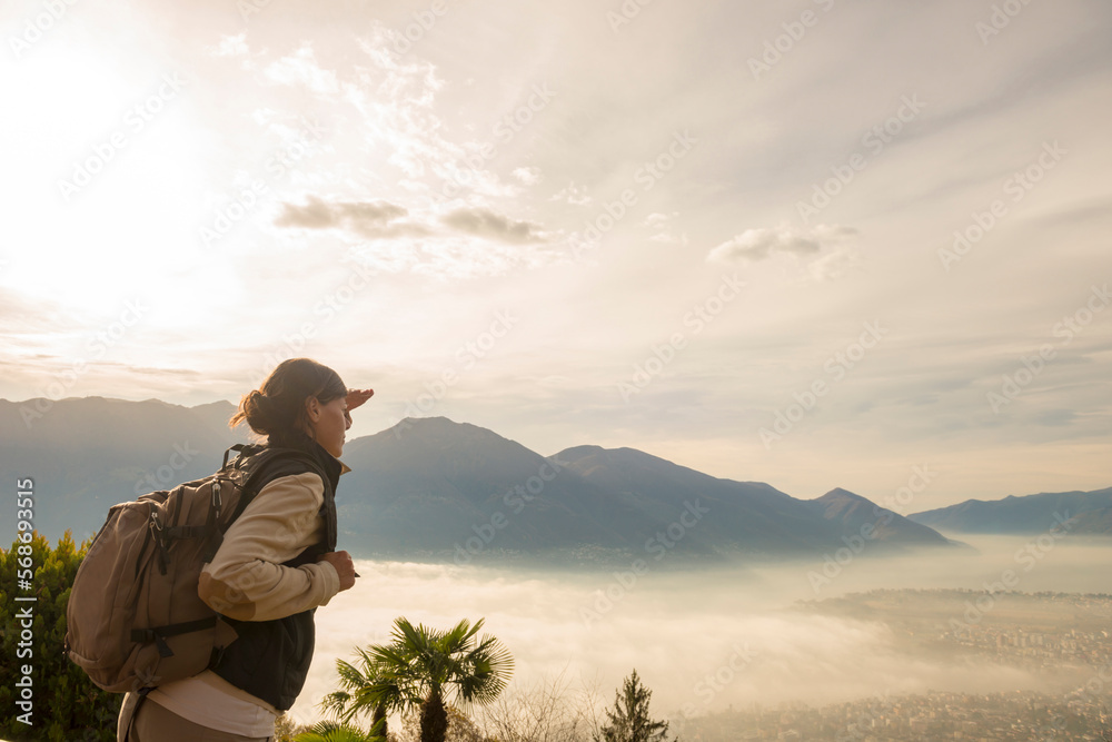 custom made wallpaper toronto digitalWoman with Backpack Enjoy Panoramic View over Locarno with Cloudscape in Ticino, Switzerland.