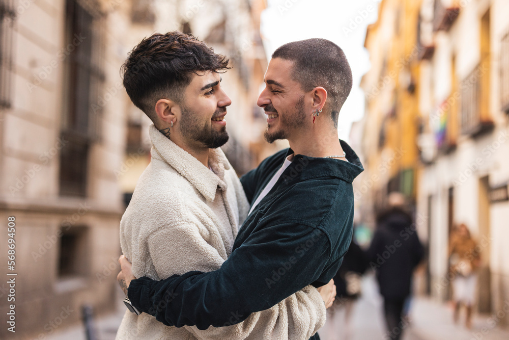Happy gay man embracing boyfriend on street Happy gay man embracing boyfriend on street