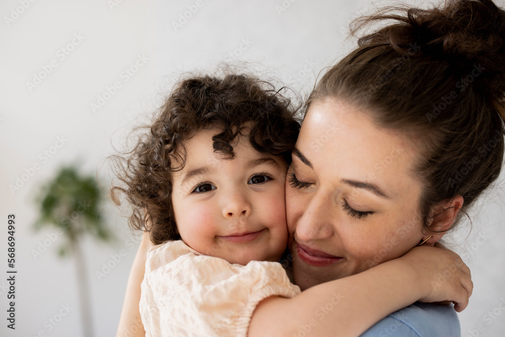 Happy mother and daughter hugging with eyes closed Happy mother and daughter hugging with eyes closed