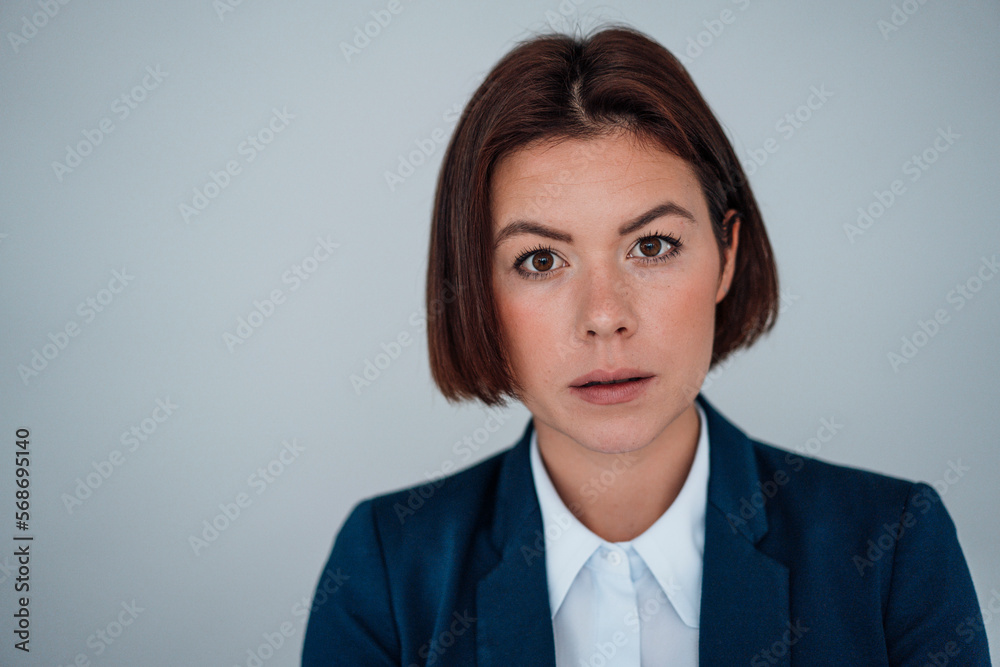 Young businesswoman with short hair in front of gray wall Young businesswoman with short hair in front of gray wall