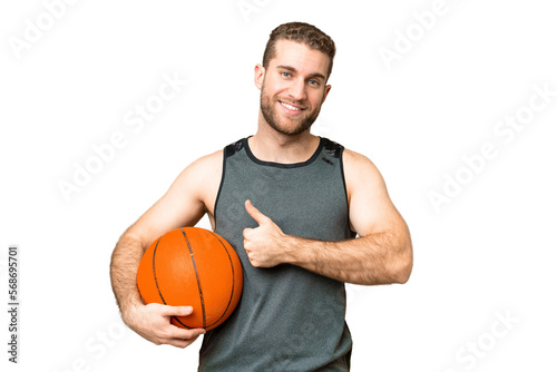 Handsome young man playing basketball over isolated chroma key background giving a thumbs up gesture