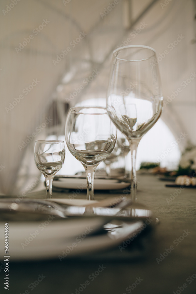 Wedding. Banquet. The chairs and round table for guests, served with cutlery, flowers and crockery and covered with a tablecloth