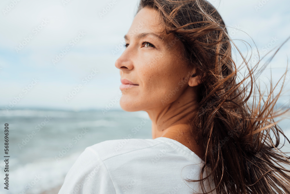 Contemplative woman with long hair at beach Contemplative woman with long hair at beach