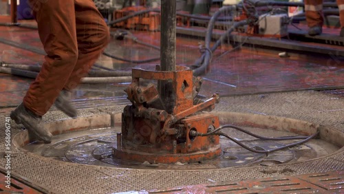 Drilling platform. Rotor table. Drilling pipe goes down. Dirty water poured from above. Accident