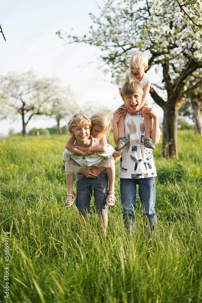Happy girl and boys enjoying together in front of apple tree Happy girl and boys enjoying together in front of apple tree