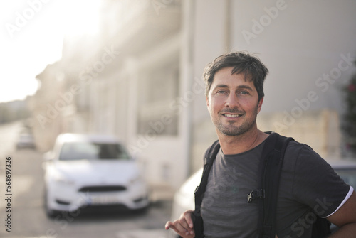 portrait of man with backpack in the street