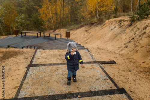 Small boy in park walking up the stairs and thinking during autumn photo