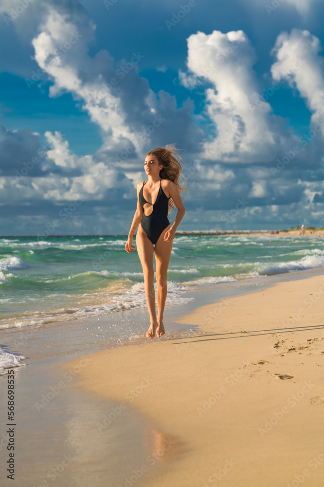 Bali. Woman in bikini on the tropical beach. Summer portrait of young beautiful girl on beach with bikini. Beautiful young woman on the beach. Freedom and carefree concept.