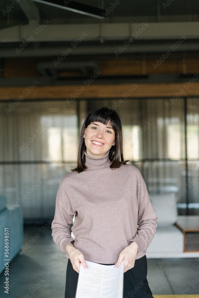 Portrait of smiling businesswoman holding document in office Portrait of smiling businesswoman holding document in office