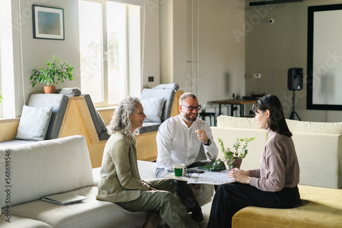 Businessman and businesswoman having a meeting with client in office photo