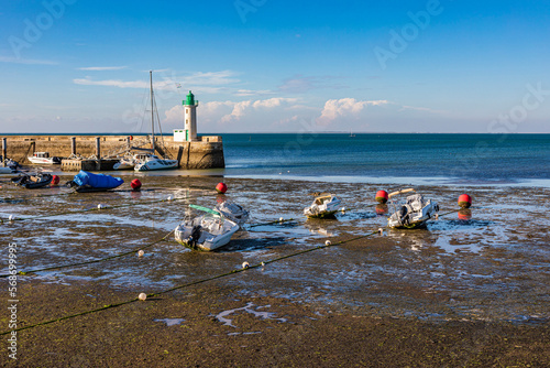 France, Nouvelle-Aquitaine, La Flotte, Boats left on beach with lighthouse in background photo