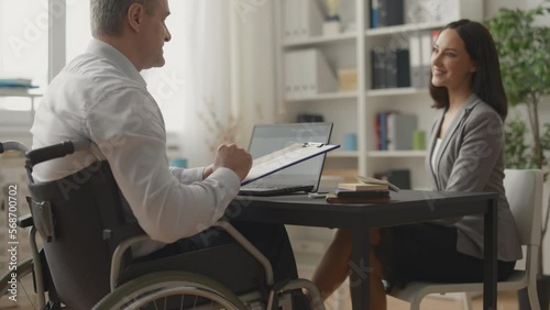Man in wheelchair interviewing young woman for job, equal career opportunities
