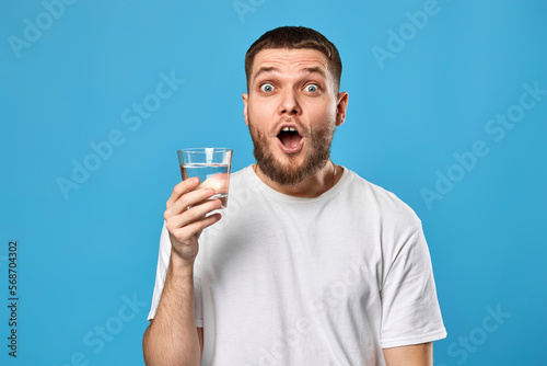 surprised handsome man with drinking glass of water