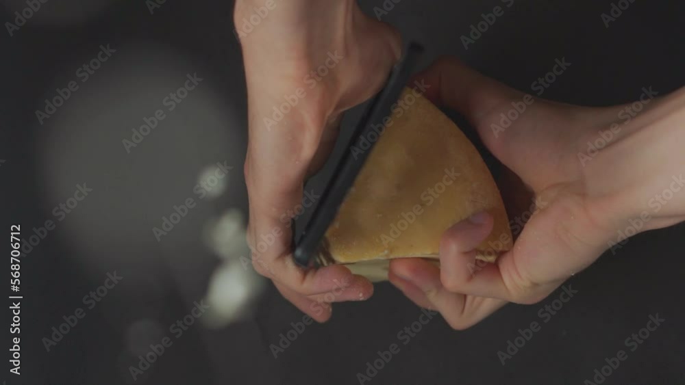 manos rallando queso parmesano con un rallador en camara lenta