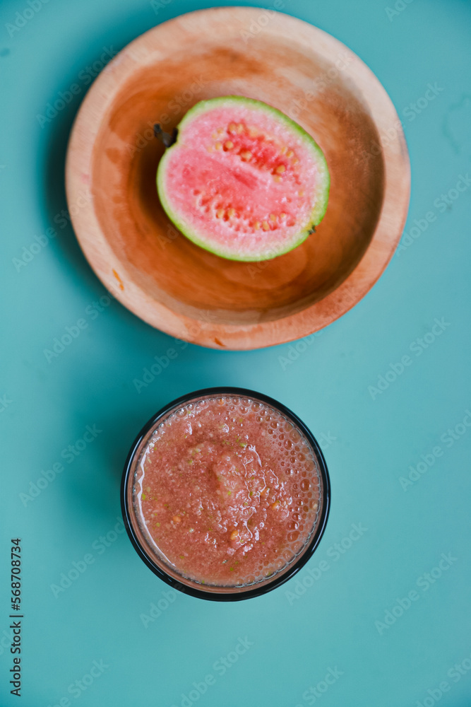 Flat lay of fresh guava fruit and guava juice served on blue table background Flat lay of fresh guava fruit and guava juice served on blue table background