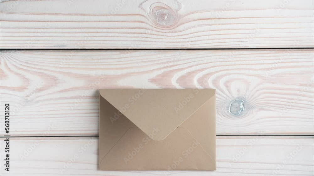 Sealed closed brown craft envelope tied with string appearing on grey wooden table. Coarse twine untying, envelope opening, blank craft paper letter showing up. Correspondence, mailing, post office.