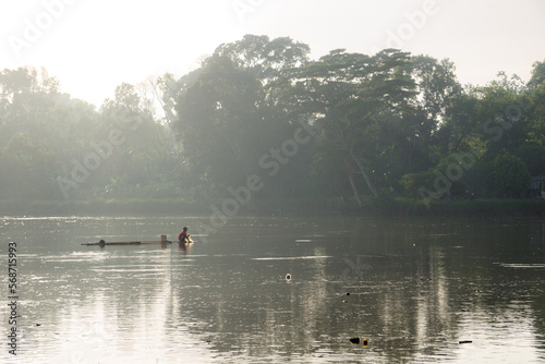 Fisherman is fishing with net on beautiful lake in the morning
