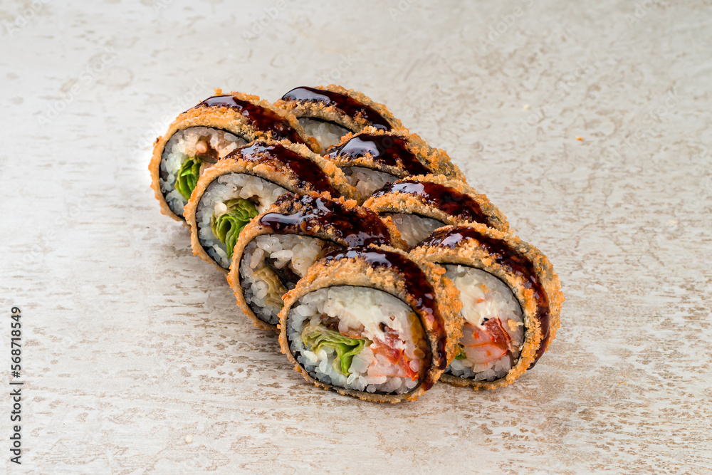 Set of tempura maki sushi rolls with shrimp, sea bass, lettuce, cream cheese, sweet pepper and teriyaki sauce. Set of tempura maki sushi rolls with shrimp, sea bass, lettuce, cream cheese, sweet pepper and teriyaki sauce.