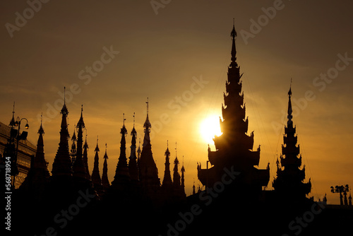 Silhouettes of Stupas of the Shwedagon Pagoda at sunset. It is Yangon's most famous landmark and the most sacred Buddhist pagoda in country. The temple is in Yangon, Myanmar.