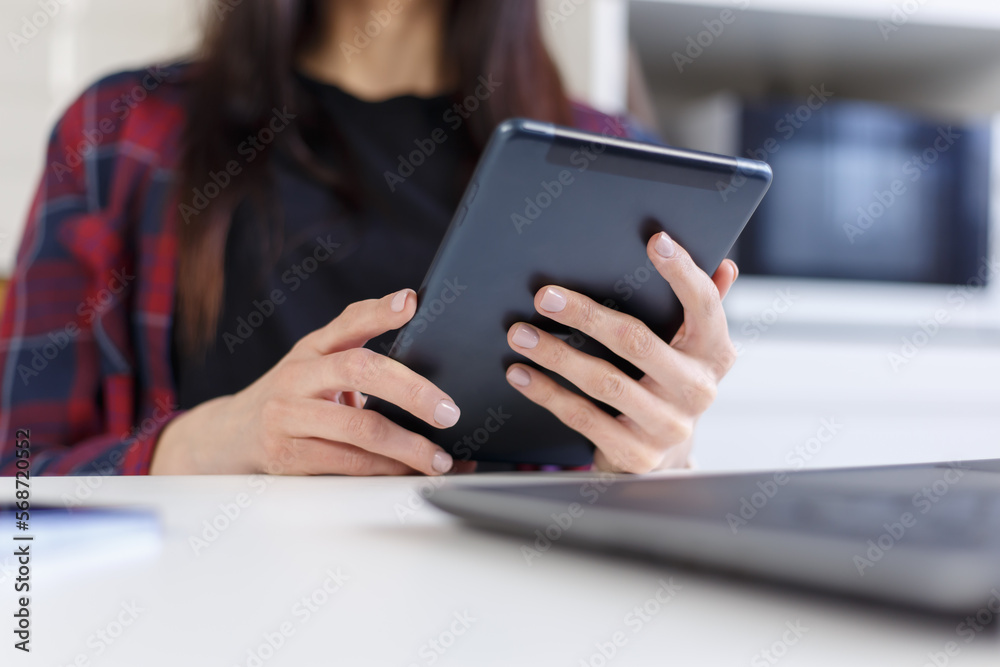 Young woman browsing internet on tablet computer. Close up photo of female person using modern portrable gadget