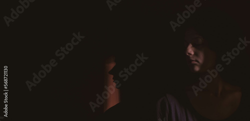 young woman on black background with light and shadow on face
